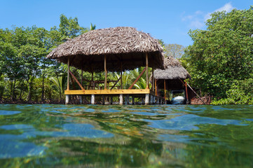 Fototapeta na wymiar Tropical hut with thatch roof from water surface