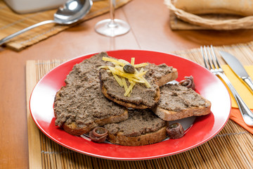 Crostini toscani di fegatini su un piatto di ceramica