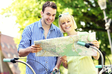 Happy couple on bikes with a map