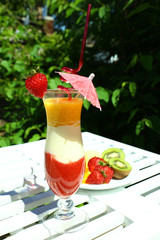 Delicious fruit smoothie on white table, outdoors