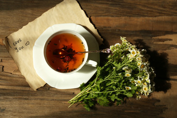 Cup of fresh herbal tea on wooden table