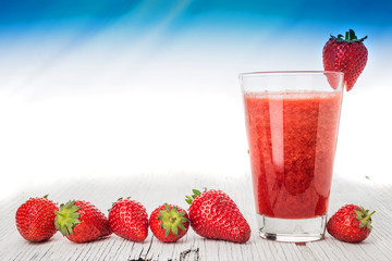 Glass with strawberry juice and berries