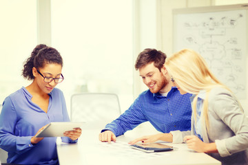 Fototapeta premium smiling team with table pc and papers working