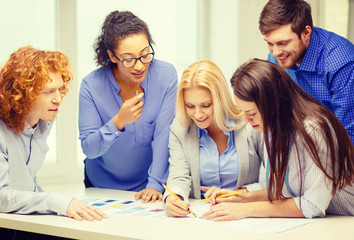 smiling creative team looking over clothes designs