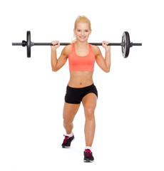 Obraz premium smiling sporty woman exercising with barbell