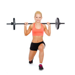 smiling sporty woman exercising with barbell