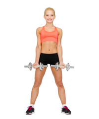 smiling sporty woman with heavy steel dumbbells