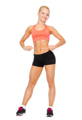 smiling sporty woman pointing at her six pack