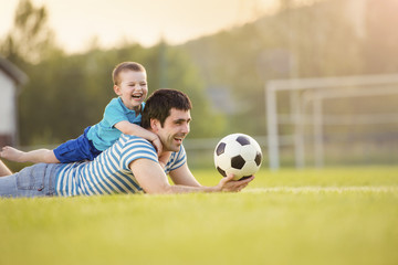 Obraz na płótnie Canvas Father and son playing football