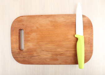 Kitchen knife and cutting board on wooden table