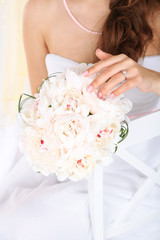 Bride holding wedding bouquet of white peonies, close-up,