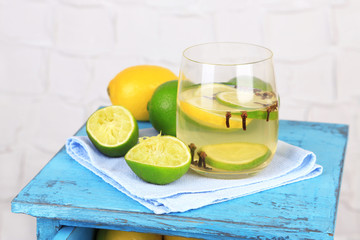 Fresh summer drink with lime and cloves in glass,