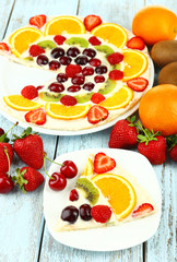 Homemade sweet pizza with fruits on wooden table, close up
