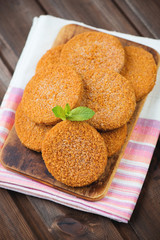 Rustic chopping board with raw fish cakes, high angle view
