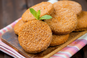 Raw fish cakes on a wooden cutting board