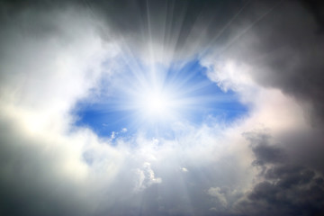 sun shining through hole in clouds