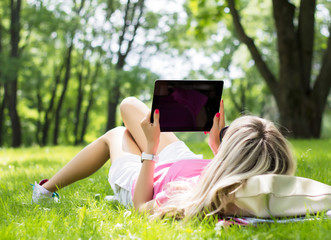Girl using tablet computer in park