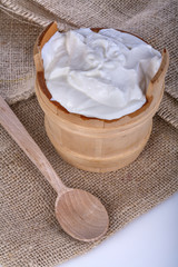 fresh yogurt in a wooden bowl on a linen background