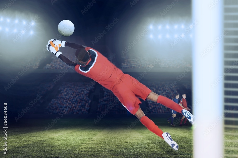 Fototapete composite image of goalkeeper in red making a save