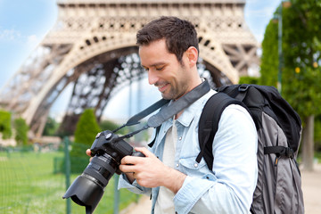 Young attractive tourist taking pictures in Paris