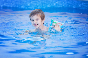 Fototapeta na wymiar Cute boy, swimming in a big pool