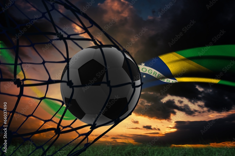Poster Composite image of football in back of the net
