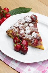 fetta di clafoutis con ciliegie su tavolo_ dolce