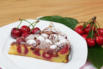 fetta di clafoutis con ciliegie su tavolo_ dolce