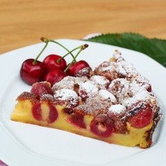 fetta di clafoutis con ciliegie su tavolo_ dolce