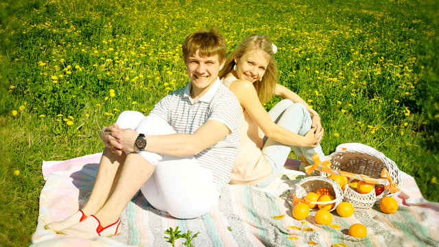 happy couple and picnic with oranges