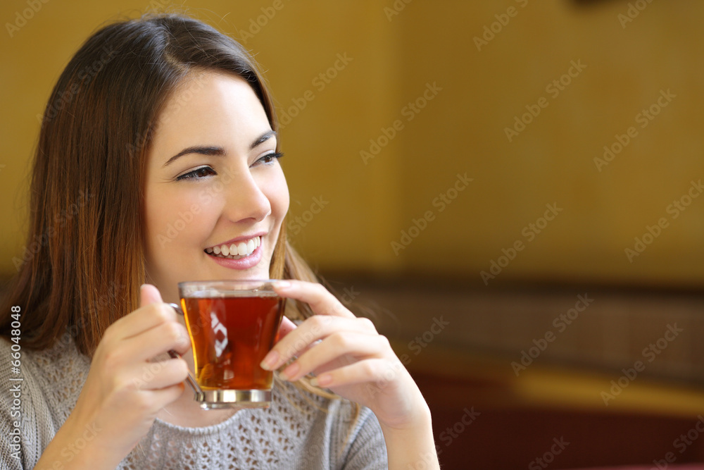 Canvas Prints Happy woman thinking holding a cup of tea in a coffee shop