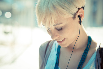beautiful young blonde short hair hipster woman listening music