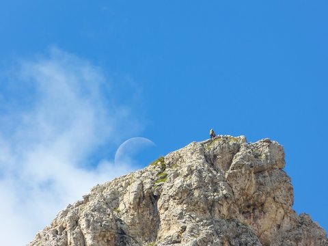 Bergsteiger auf Gipfel mit Mond