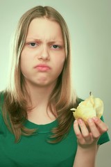 Portrait of an unhappyl teen girl with an apple