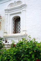Fototapeta na wymiar Barred window - Detail of an old white church