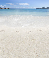 Fototapeta na wymiar traces de pas sur plage des Seychelles