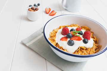 Healthy breakfast with cereals and berries in an enamel bowl