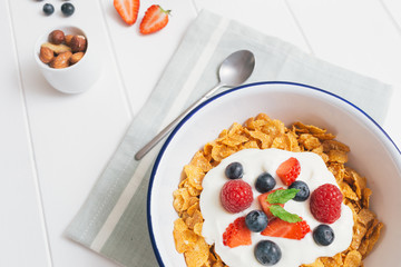 Healthy breakfast with cereals and berries in an enamel bowl