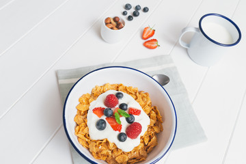 Healthy breakfast with cereals and berries in an enamel bowl