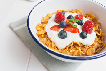 Healthy breakfast with cereals and berries in an enamel bowl