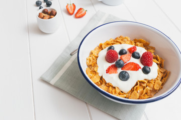 Healthy breakfast with cereals and berries in an enamel bowl