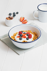 Healthy breakfast with cereals and berries in an enamel bowl