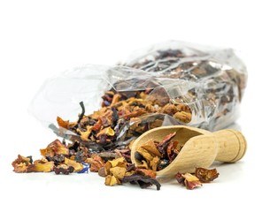 A bag of fresh tea leaves with wooden scoop on white background