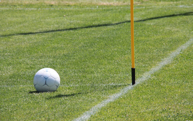 Fußball und Eckfahne auf grünem Rasen