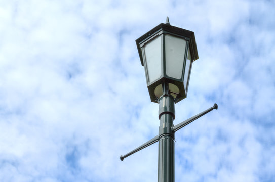 Lamp post against cloudy sky