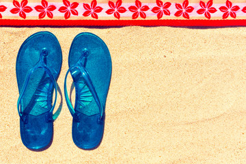 Flip flops and towel at the beach.