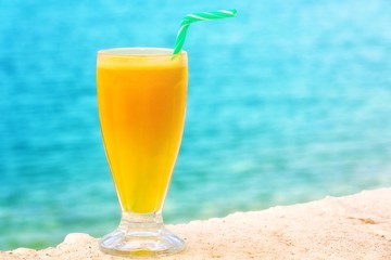 Refreshing looking orange juice,at the sea.