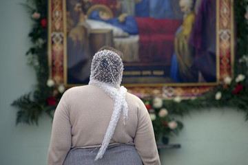 Woman  looking at the icon of the Dormition of the Virgin.