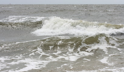 Waves with white crests inundate the sandy beach