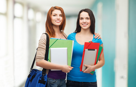 two smiling students with bag, folders and tablet